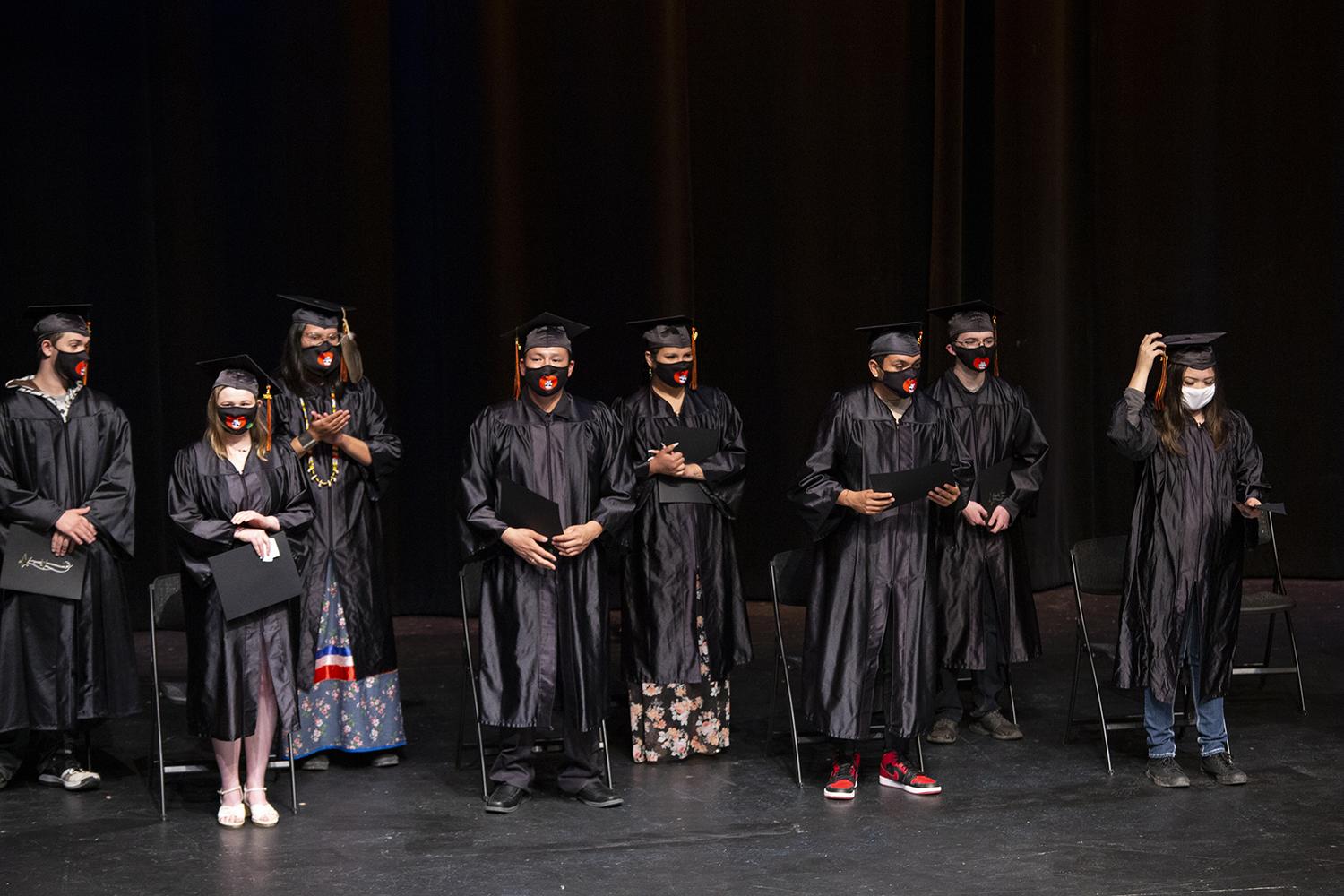 students who graduated with their high school diploma stand on stage